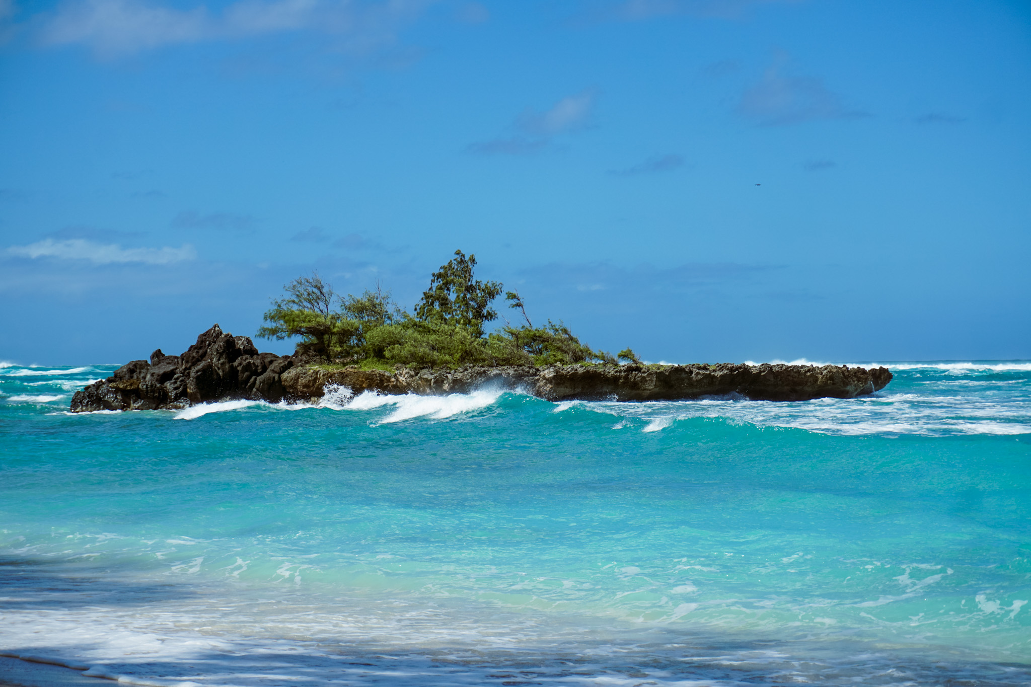 Close up of Rocky island in turquoise water at Hawaiian beach on the North Shore of Oahu