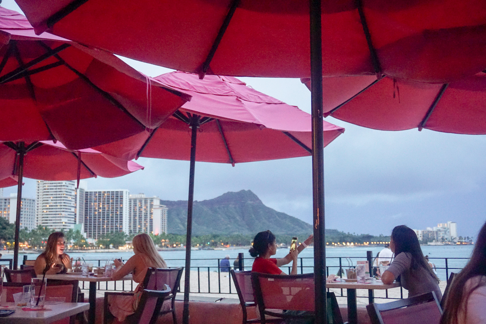 View of Diamond Head from the seating area covered in pink umbrellas