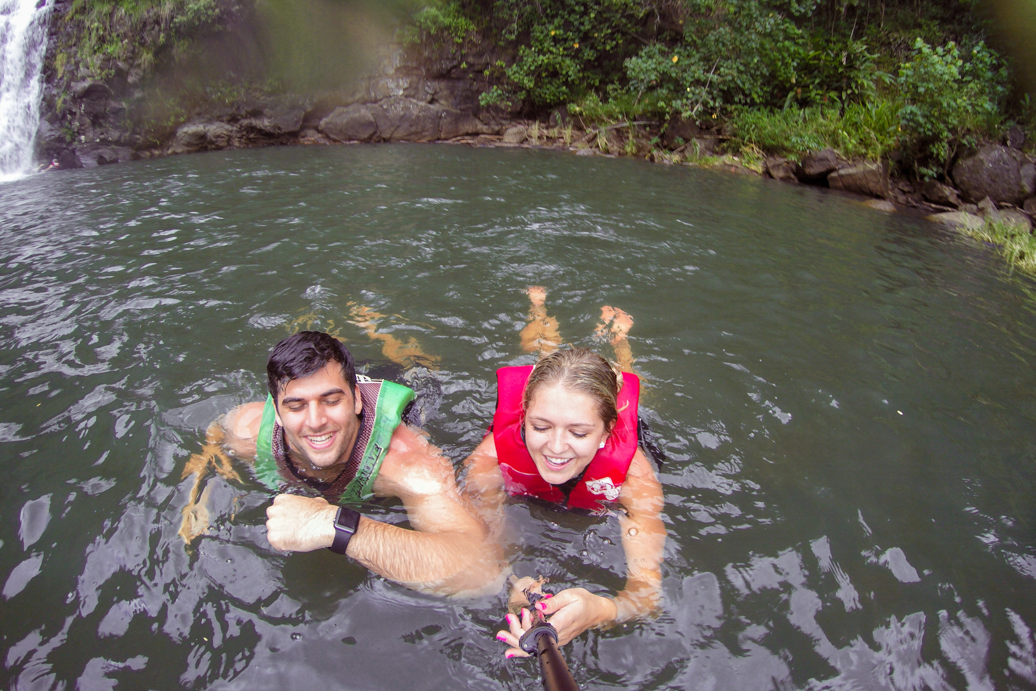 Couple in swimming hole next to Waimea Falls on Oahu Hawaii