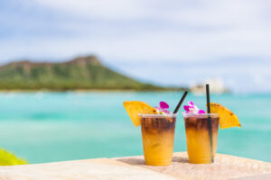 Two Mai Tai Cocktails on a balcony with diamond head in background